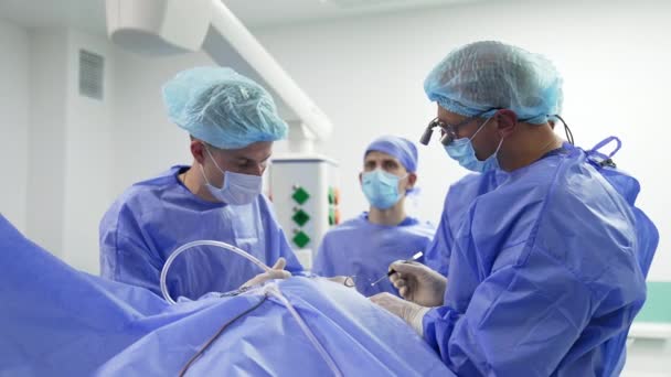 金属の伝統的な手術ツールを使用して手術を行う外科医の協力チーム 手術中の医療専門家の正確な作業 — ストック動画