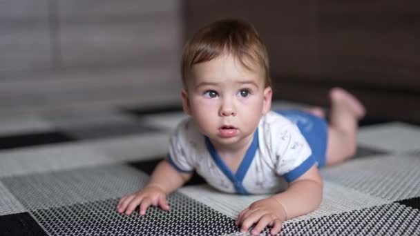 Spokojny Biały Chłopczyk Leży Brzuchu Podłodze Uroczy Dzieciak Wygląda Zaskoczonego — Wideo stockowe