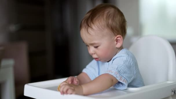 Милый Мальчик Сидящий Столом Кормления Весело Играет Едой Активный Малыш — стоковое видео
