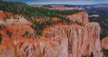 Utah, ABD 'deki Ulusal Bryce Canyon Parkı' nın nefes kesici manzarası. Gökyüzünden portakal kayaları ve yeşil çam ağaçları görünüyor.