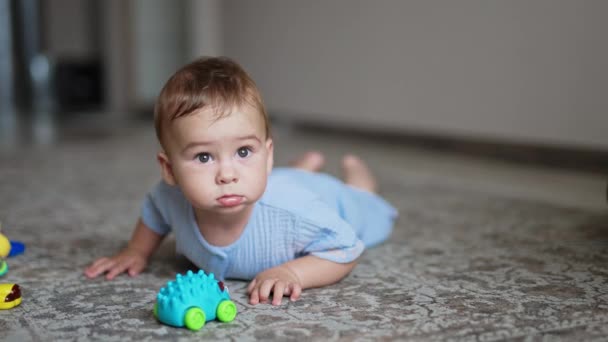 Adorable Baby Boy Lies Carpet Toy Front Him Focused Little — Stock Video