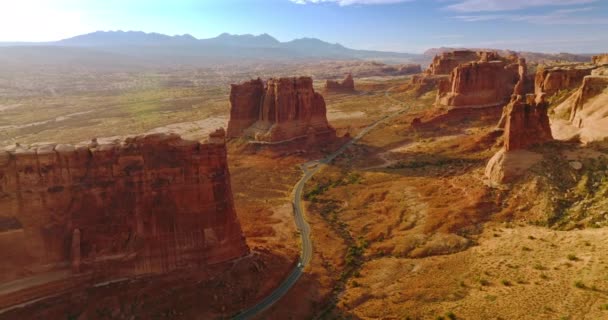 独立的山孤独地站在沙漠的土地上 高速公路在美国犹他州令人惊奇的峡谷中穿行 — 图库视频影像
