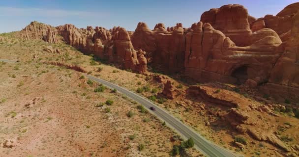奇妙な形をしたオレンジ色の岩に沿って移動する自動車 アーチズ国立公園の素晴らしい峡谷 アメリカ — ストック動画