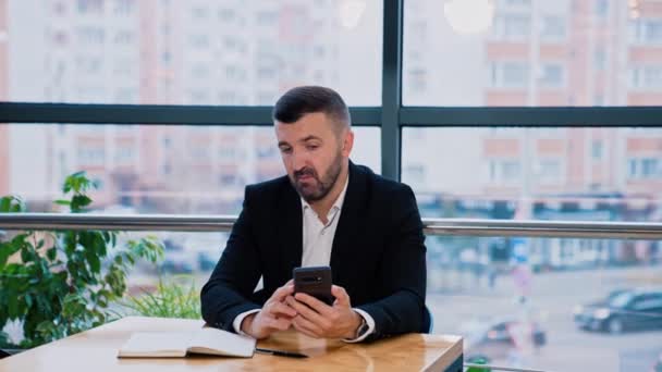 Selbstbewusster Millennial Mann Mit Seinem Smartphone Tisch Sitzend Bärtiger Geschäftsmann — Stockvideo