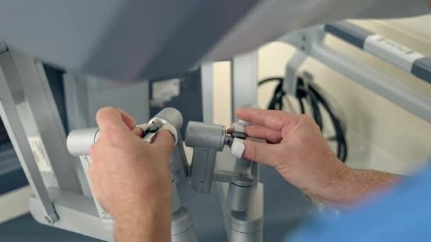 手術室で近代的な未来装置を操作する医療専門家 高度な装置のハンドルを動かす男性の手 クローズアップ — ストック動画