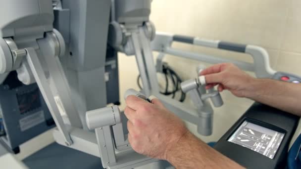 手術室の高度なロボット機器の手動制御 Vinciロボットを操作する男性の手を閉じる — ストック動画