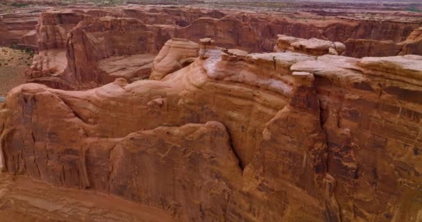 橘红色的山峰和山顶环抱着 美国犹他州拱门国家公园岩石上的无人机镜头 — 图库视频影像