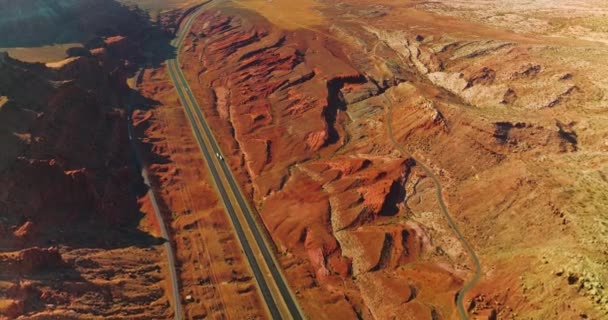落基橙色的风景穿过高速公路 很少有汽车经过 从空中看阳光普照的峡谷风景 — 图库视频影像