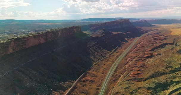 ユタ州の素晴らしい山の下を走るハイウェイとトラック 曇りの空の背景にある渓谷の美しい晴れた景色 — ストック動画