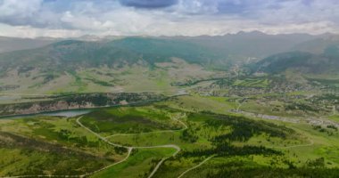 Dağlık bölgedeki nehirlerin yakınındaki inanılmaz güzel yeşil vadiler. Colorado 'da dağın eteğindeki küçük bir kasaba. Arkaplanda dramatik bir gökyüzü var..