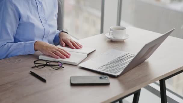 一个无法辨认的女人坐在办公桌前 女用手关闭笔记本电脑和纸质笔记本 办公室职员完成工作天 — 图库视频影像