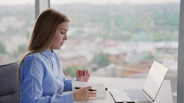 Empleada Oficina Sienta Mesa Con Portátil Mujer Mira Cuaderno Papel — Vídeos de Stock