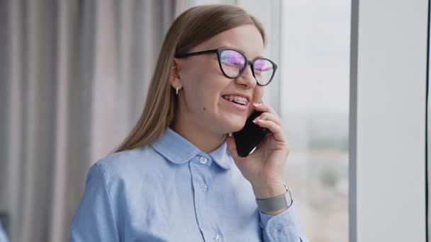 Счастливая Улыбающаяся Женщина Очках Говорит Телефону Блокнотом Руке Коллеги Общаются — стоковое видео