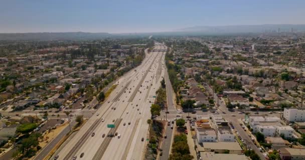 多数の車が大都市を通り抜ける複数の車線の高速道路 空中からのロサンゼルスの晴れた写真 — ストック動画