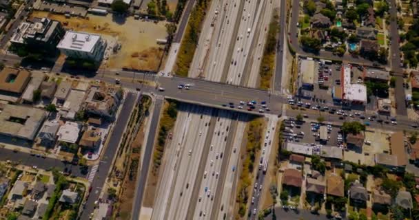 トラフィックが多いため 幅広い多車線高速道路に架かる道路橋 ロサンゼルス カリフォルニア 晴れた暑い日に高速道路を降りるドローン — ストック動画