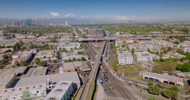 加利福尼亚州洛杉矶市区的低矮建筑物 繁忙的道路穿过城市 多辆汽车快速行驶 阳光明媚的镜头 顶部视图 — 图库视频影像