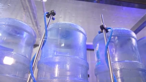 Синие Большие Бутылки Кладут Вверх Ногами Моют Флаконы Распыляются Водой — стоковое видео