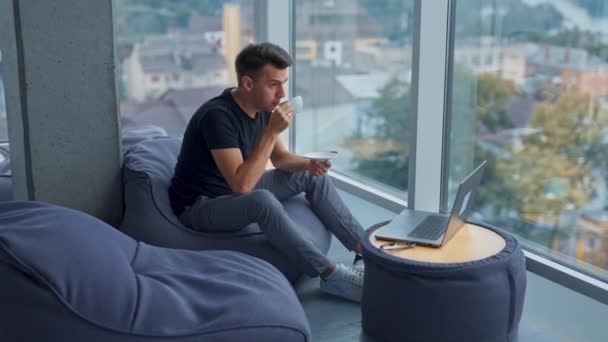 Homem Caucasiano Senta Cadeira Beber Café Empregado Masculino Olha Para — Vídeo de Stock