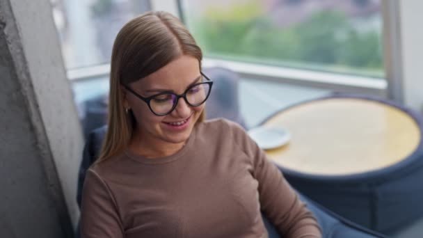笑着轻松的金发女士在笔记本电脑上打字 在舒适的现代办公环境中工作 高角度视图 — 图库视频影像