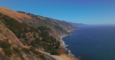Okyanusla buluşan dağların muhteşem manzarası. Çam ağaçlarının arasındaki kayalıklardaki yollar. Kaliforniya 'daki Big Sur Morro Körfezi, ABD.