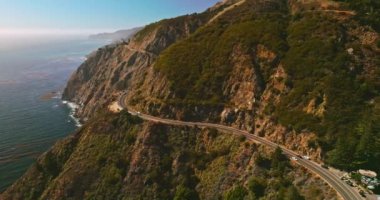 Big Sur Morro Körfezi kayaları okyanus sularının üzerinde yükseliyor. Güneşli bir günde Pasifik Okyanusu kıyısındaki dağlarda otoyol..