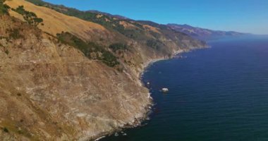 Dağların üzerinden uçup okyanusun derinliklerine iniyorlar. Güneşli bir günde Amerika Birleşik Devletleri 'nin Kaliforniya eyaletinin Big Sur Morro Körfezi' nde muhteşem kayalık manzarası..