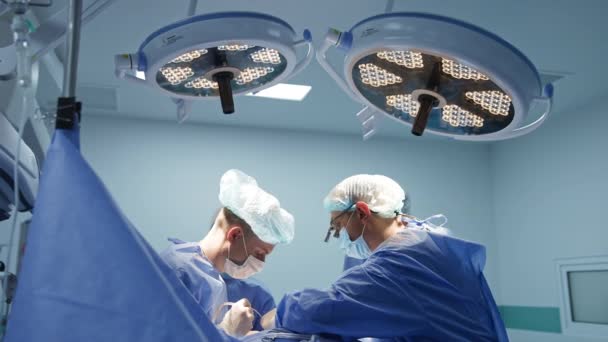 Grandes Lâmpadas Ligadas Sala Cirurgia Dois Cirurgiões Conduzindo Operação Teatro — Vídeo de Stock