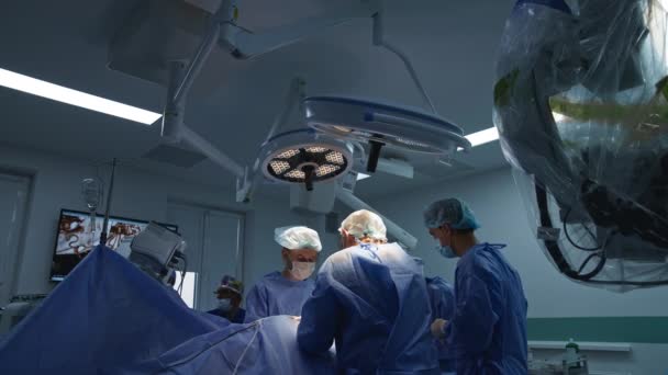 수술을 수행하는 서있는 외과의 배경에서 — 비디오