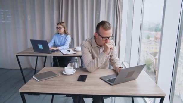 在现代办公室工作的办公室职员 镜头正在接近坐在办公桌前工作并接电话的男人 — 图库视频影像