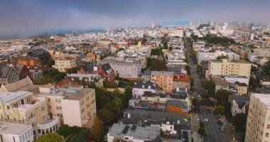 İnsansız hava aracı gündüz vakti güzel şehir mimarisinin üzerinde yükseliyor. Parlak San Francisco 'da mavi sisli gökyüzünün arka planında.