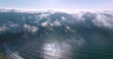Kıyı şeridine sudan yayılan yoğun beyaz sis. Güneşli yaz gününde inanılmaz bir sis bulutu. Hava görünümü.