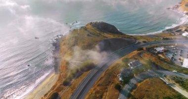 Montara, California, ABD 'deki kayalıklardan geçen yol. Montara Eyalet Sahili 'ndeki tepeden inen insansız hava aracı..