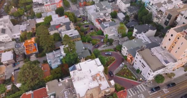 サンフランシスコの地区の波の道路で非常にゆっくりと移動する私用車 昼間の美しい都市の街並みを映した空中映像 — ストック動画