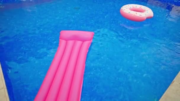水面の水泳円そして膨脹可能なマットレス プール内の水泳器具は人なし 上からの眺め — ストック動画