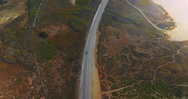 高速公路穿过干燥的岩石景观 无人机降落在高速公路上 汽车飞驰而过 — 图库视频影像