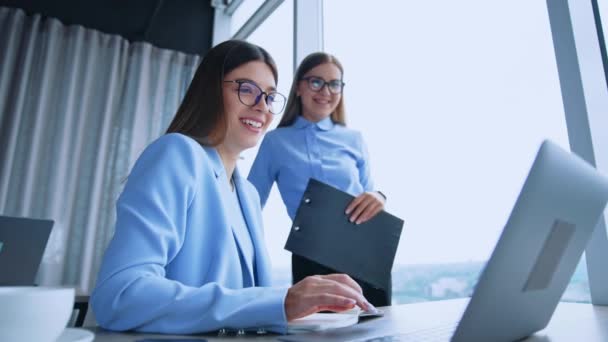 現代のオフィスにいる女性社員の幸せ 女性は笑顔でノートパソコンの画面を見て びっくりする ローアングルビュー — ストック動画