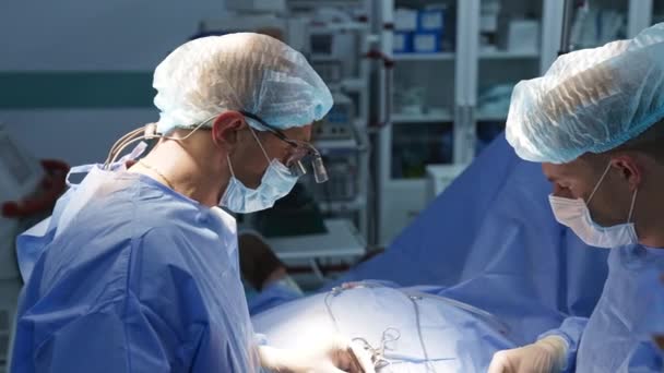 공구를 사용하여 수술을 수행하는 외과의사 닫으세요 배경에 장비를 현대적인 수술실 — 비디오