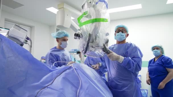 Male Surgeons Team Operation Chief Doctor Moves Microscope Away Patient — Stock Video