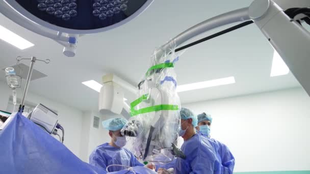 Cerrahlardan Oluşan Bir Ekip Ameliyatta Güçlü Mikroskop Kullanıyor Gelişmiş Ekipmanlı — Stok video