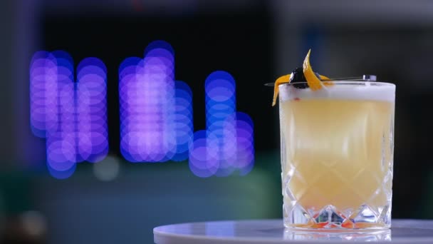 在旋转的白色桌子上的宽玻璃杯中装饰精美的鸡尾酒 酒水在酒吧里供应 靠近点模糊的背景 — 图库视频影像