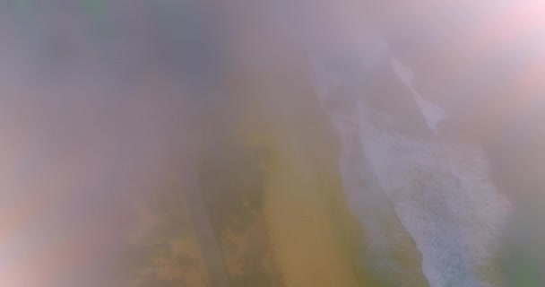 泡沫浪涌上沙滩 无人机在大雾中降落在经过海滩的路上 — 图库视频影像