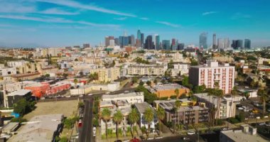 Los Angeles, California, ABD 'nin inanılmaz güneşli fotoğrafı. İnsansız hava aracı şehrin üzerinde yükseliyor. Arkaplanda gökdelenler.