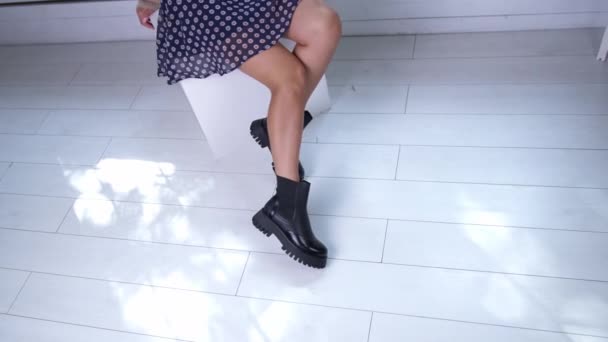 Неузнаваемая Девушка Синей Короткой Юбке Демонстрирует Обувь Черные Массивные Сапоги — стоковое видео