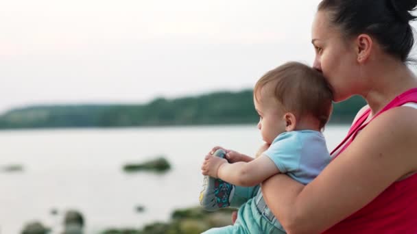 Летом Мама Держит Руках Младенца Сидящего Реки Любить Мамочку Целующую — стоковое видео