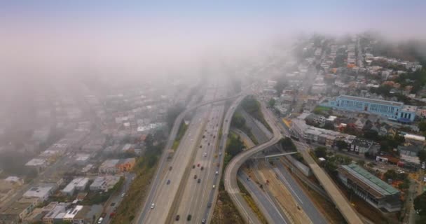 重く複雑な道路が厚い霧に向かっている 霧の日中は高速道路を走る車が多かった トップビュー — ストック動画