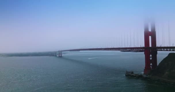 旧金山著名的标志性的金门大桥 桥的上部在雾中 在桥下航行的船 — 图库视频影像