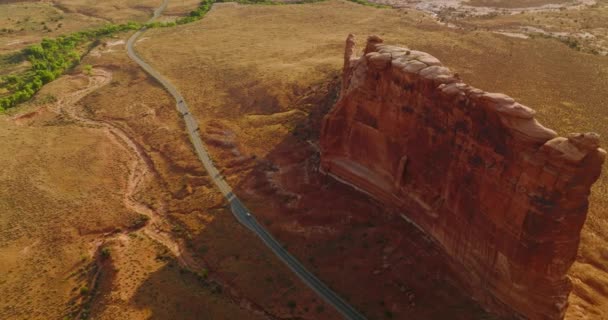 大岩石峡谷墙壁 顶部有圆形光滑的石头和顶部 公路穿过沙漠 有几辆车继续前行 空中展望 — 图库视频影像