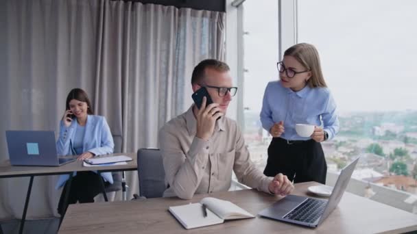 Male Employee Sitting Desk Starting Phone Conversation Lady Blue Shirt — Stock Video