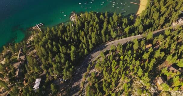 公路在松树林中 车上的车很少 蓝色湖畔有许多小船 空中景观 — 图库视频影像