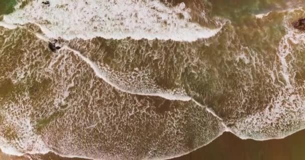 砂浜を覆う白い広い泡立った波 風の強い天候で海岸を降下するドローン映像 — ストック動画